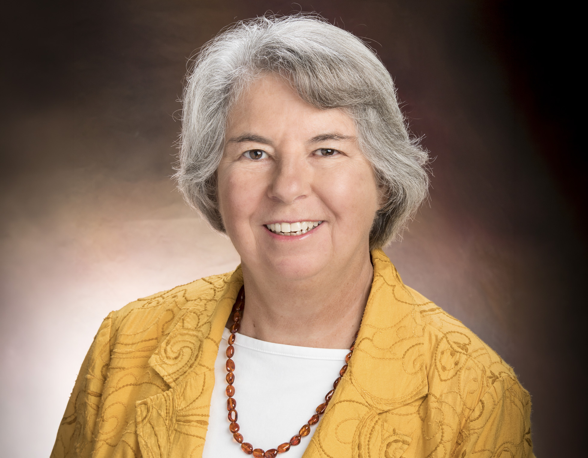 Portrait of Dr. Virginia Stallings smiling in a yellow jacket.